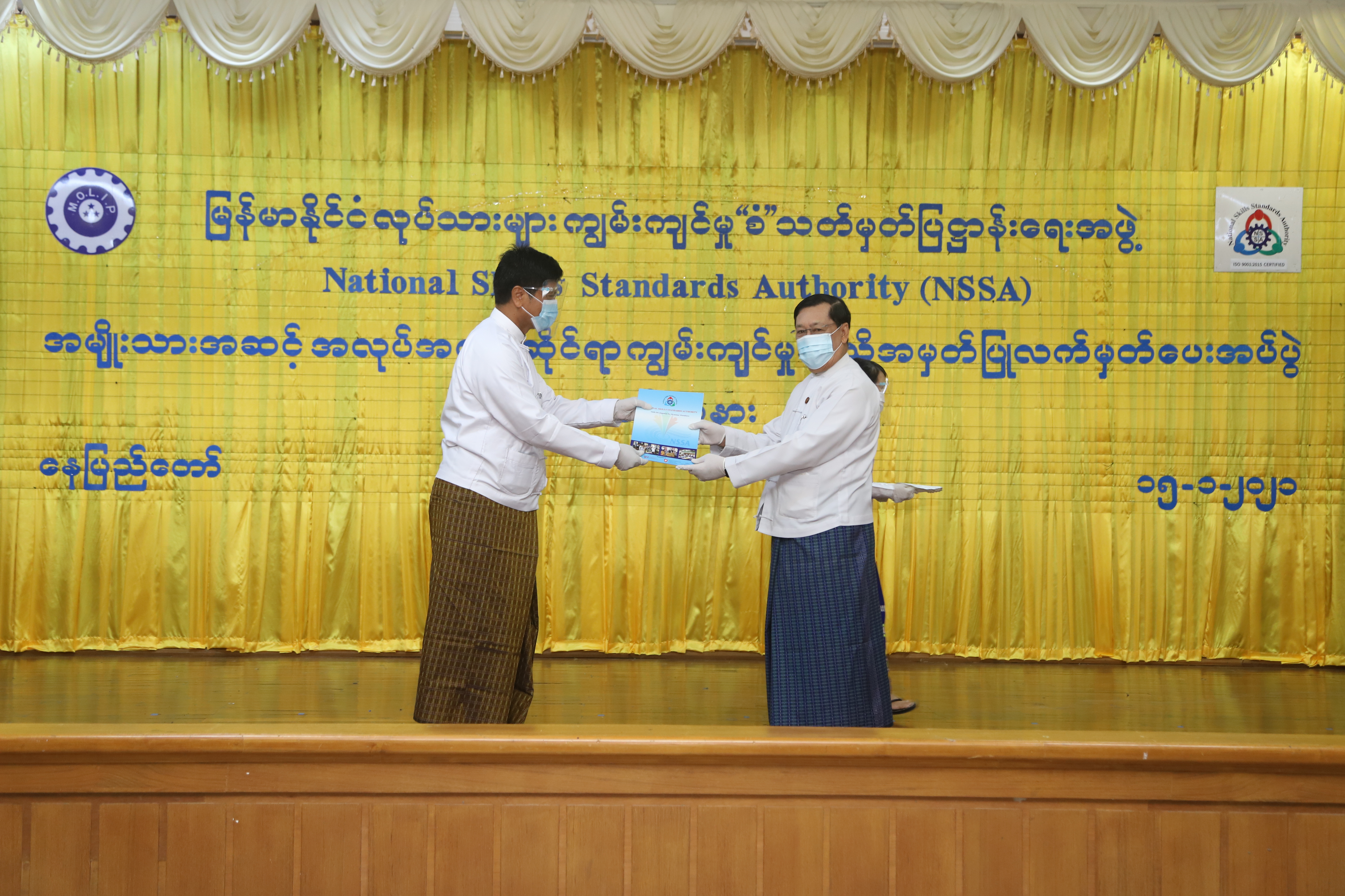 မြန်မာနိုင်ငံ လုပ်သားများ ကျွမ်းကျင်မှု “စံ” သတ်မှတ်ပြဋ္ဌာန်းရေးအဖွဲ့ အမျိုးသားအဆင့် အလုပ်အကိုင်ဆိုင်ရာ ကျွမ်းကျင်မှုအသိအမှတ်ပြုလက်မှတ်ပေးအပ်ပွဲအခမ်းအနားတွင် အသိအမှတ်ပြုလက်မှတ်ရရှိသည့် စစ်ဆေးအကဲဖြတ်သူ တစ်ဦးအား အသိအမှတ်ပြုလက်မှတ်ပေးအပ်စဉ်
